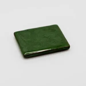 A closed green leather wallet on a white surface.